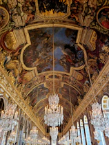 a large room with chandeliers and paintings on the ceiling