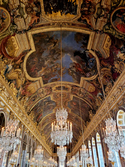 a large room with chandeliers and paintings on the ceiling