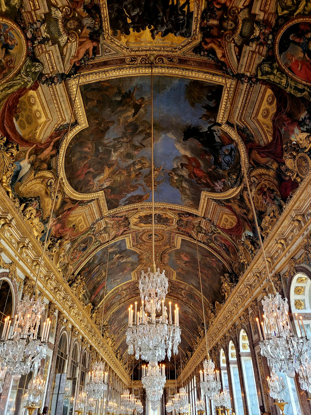 a large room with chandeliers and paintings on the ceiling