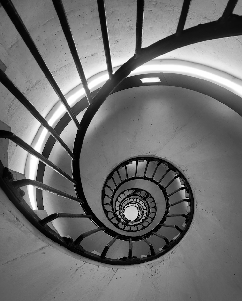 a black and white photo of a spiral staircase