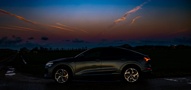 A sleek modern car parked by a scenic road at sunset, symbolizing reliability and ease