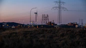 A panoramic view of an energy plant at sunset, symbolizing reactivation and growth.