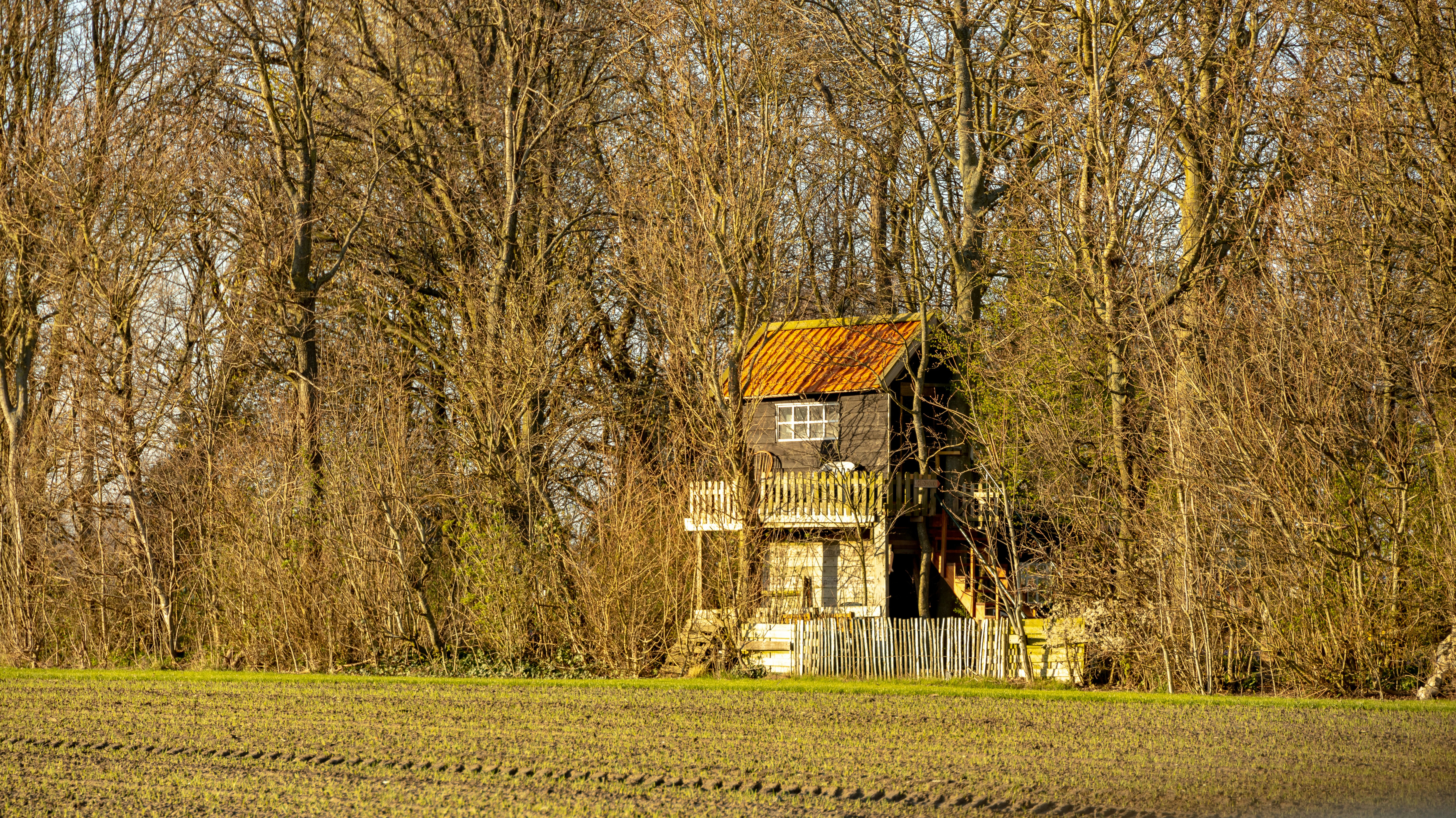 an old run down house in the middle of a field