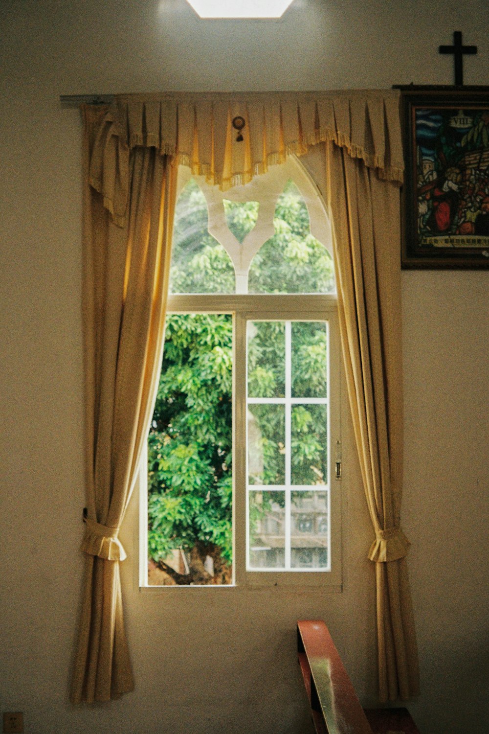 une fenêtre avec des rideaux et un banc devant