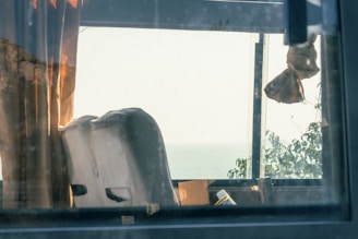 A peaceful window view framed by flowing sage green curtains with gentle sunlight streaming in.