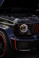 Close-up of a shiny black SUV's front grille with red accents