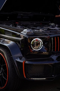 Close-up of a sleek black automotive fridge with blue LED display on a camping site