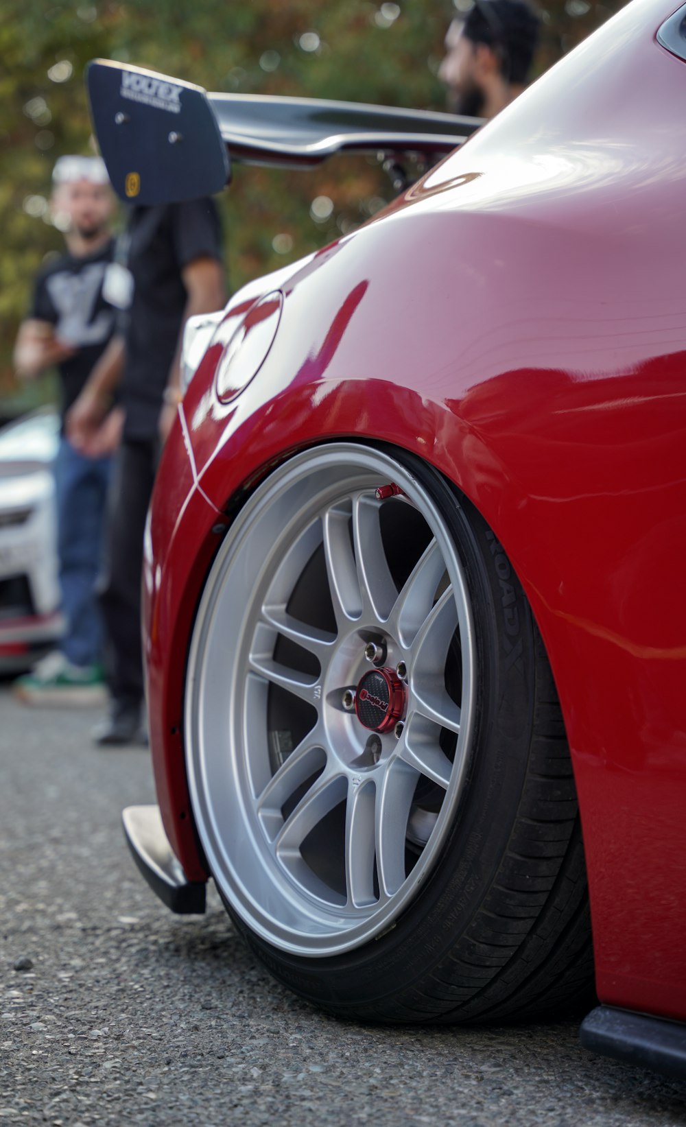 a close up of a red sports car on a street