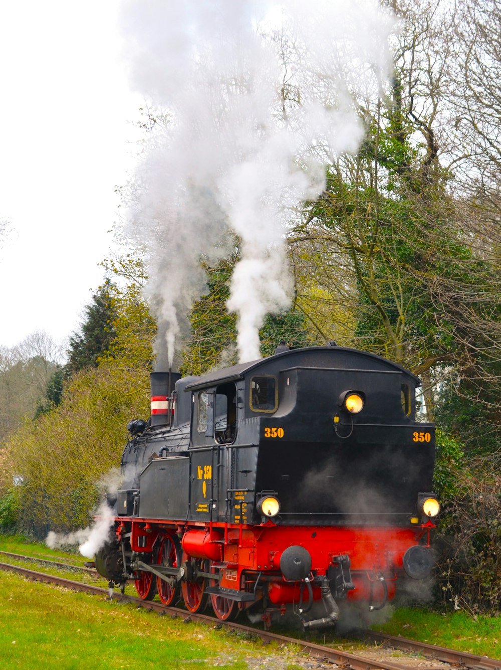 Un tren negro y rojo viajando por las vías del tren