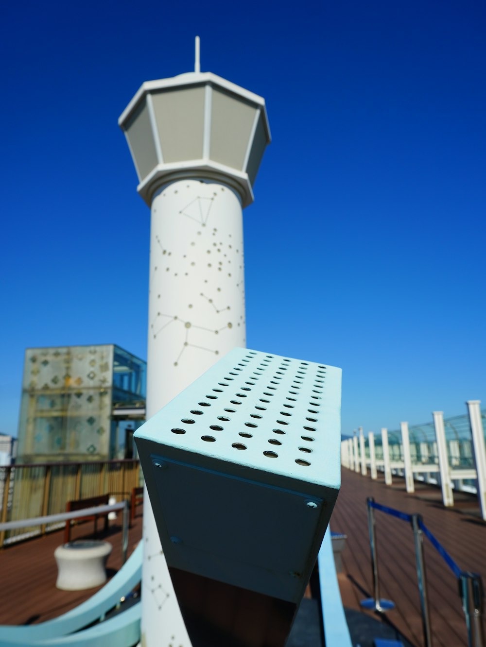 a tall white tower sitting on top of a wooden pier