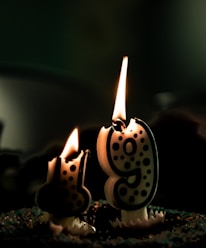 A close-up of a birthday cake with the number 21 in candles glowing warmly.