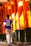 A person wearing a sports jersey with the name and number 'Neymar Jr 10' walks through a passageway lined with tall, vibrant orange pillars. The pillars are partially shaded and have some text written on them, likely in Japanese characters. The ground is paved, and the scene is illuminated by warm sunlight.
