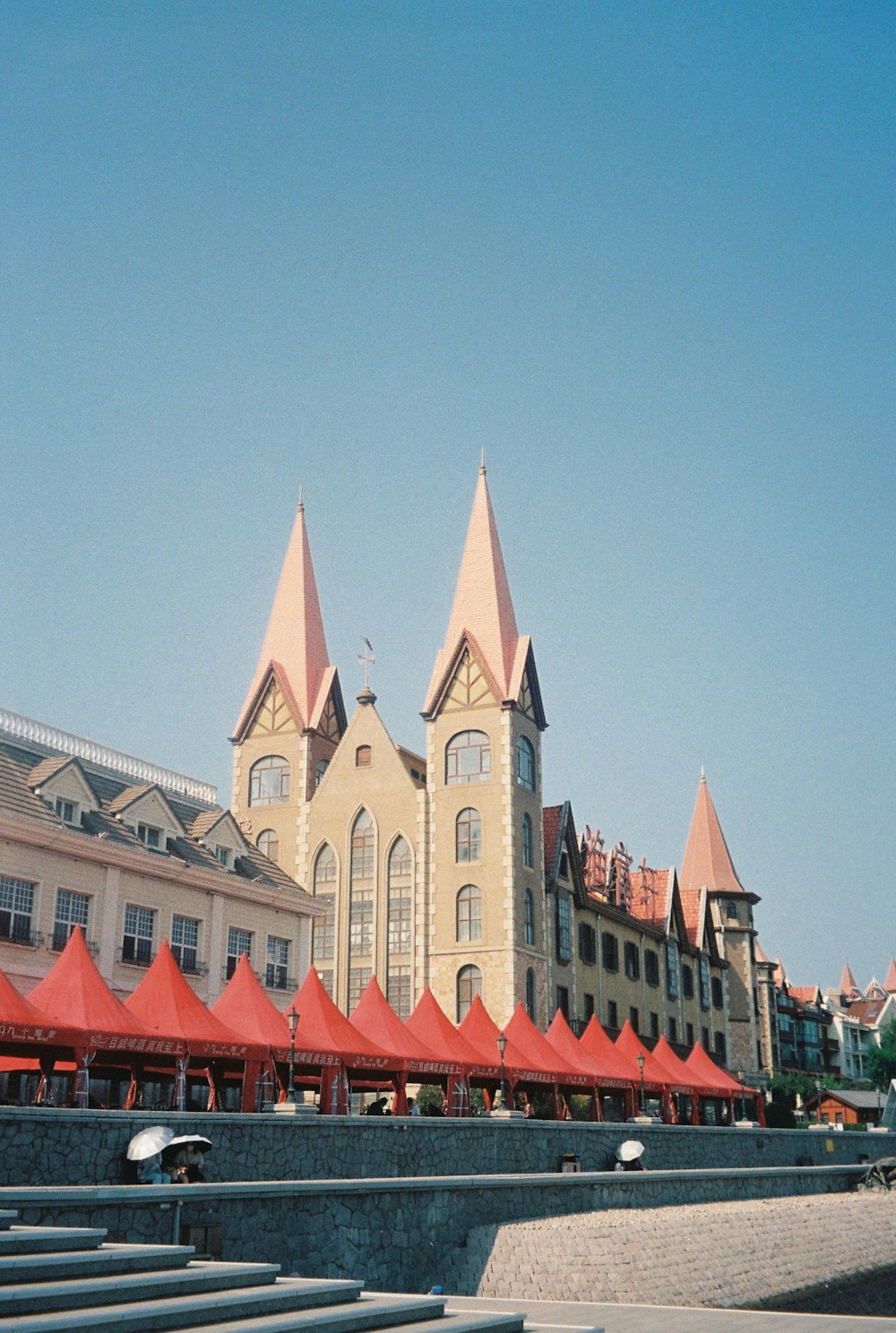 a large building with red tents in front of it