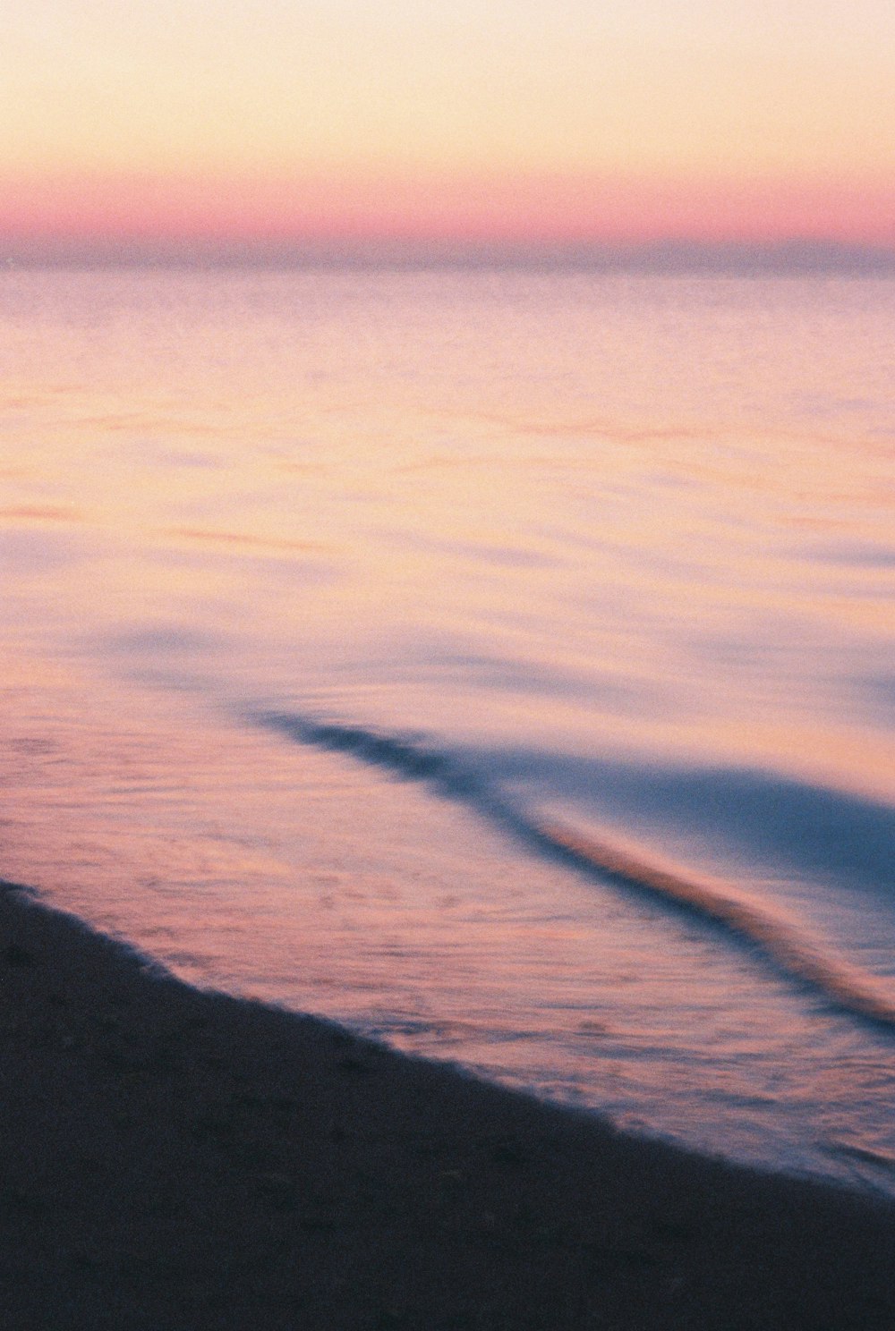 a person standing on a beach holding a surfboard