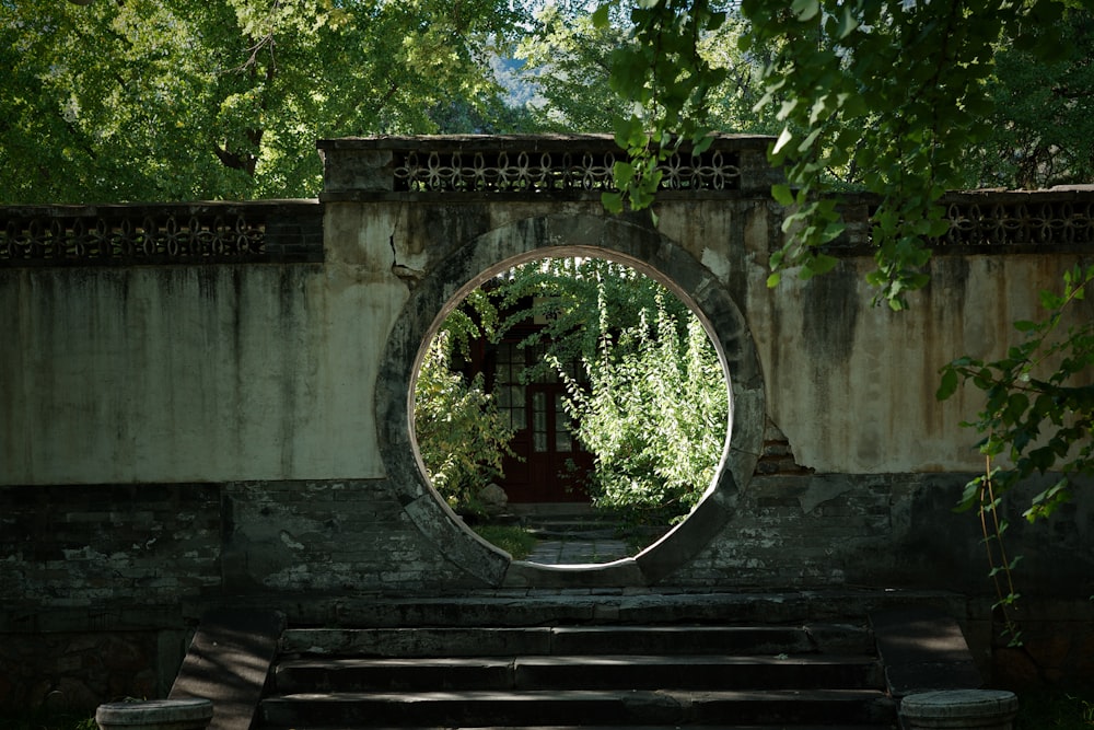 a stone wall with a circular mirror in the middle of it
