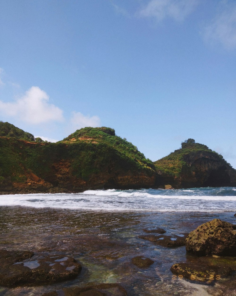 a couple of small hills sitting on top of a beach