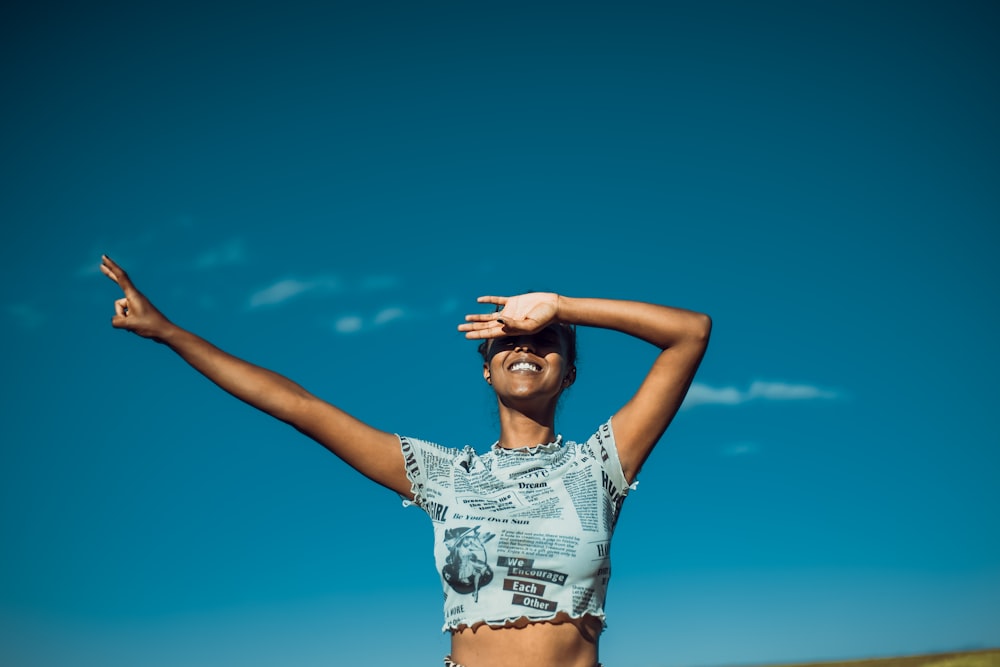 a woman standing in a field with her arms outstretched