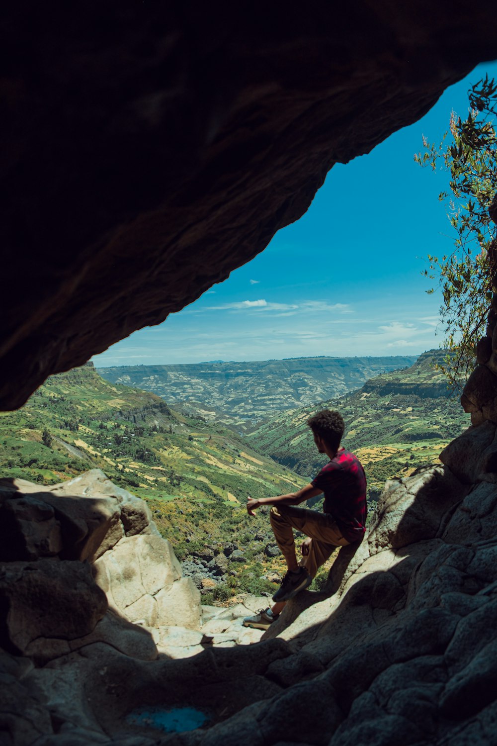 a man sitting on top of a rock formation