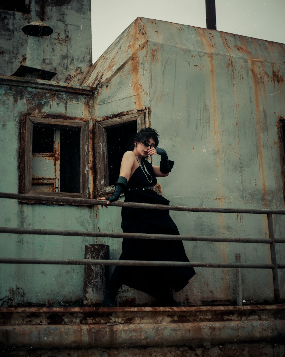 a woman in a black dress walking up a set of stairs