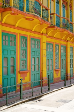 Exterior house facade painted vibrant yellow with detailed trim.