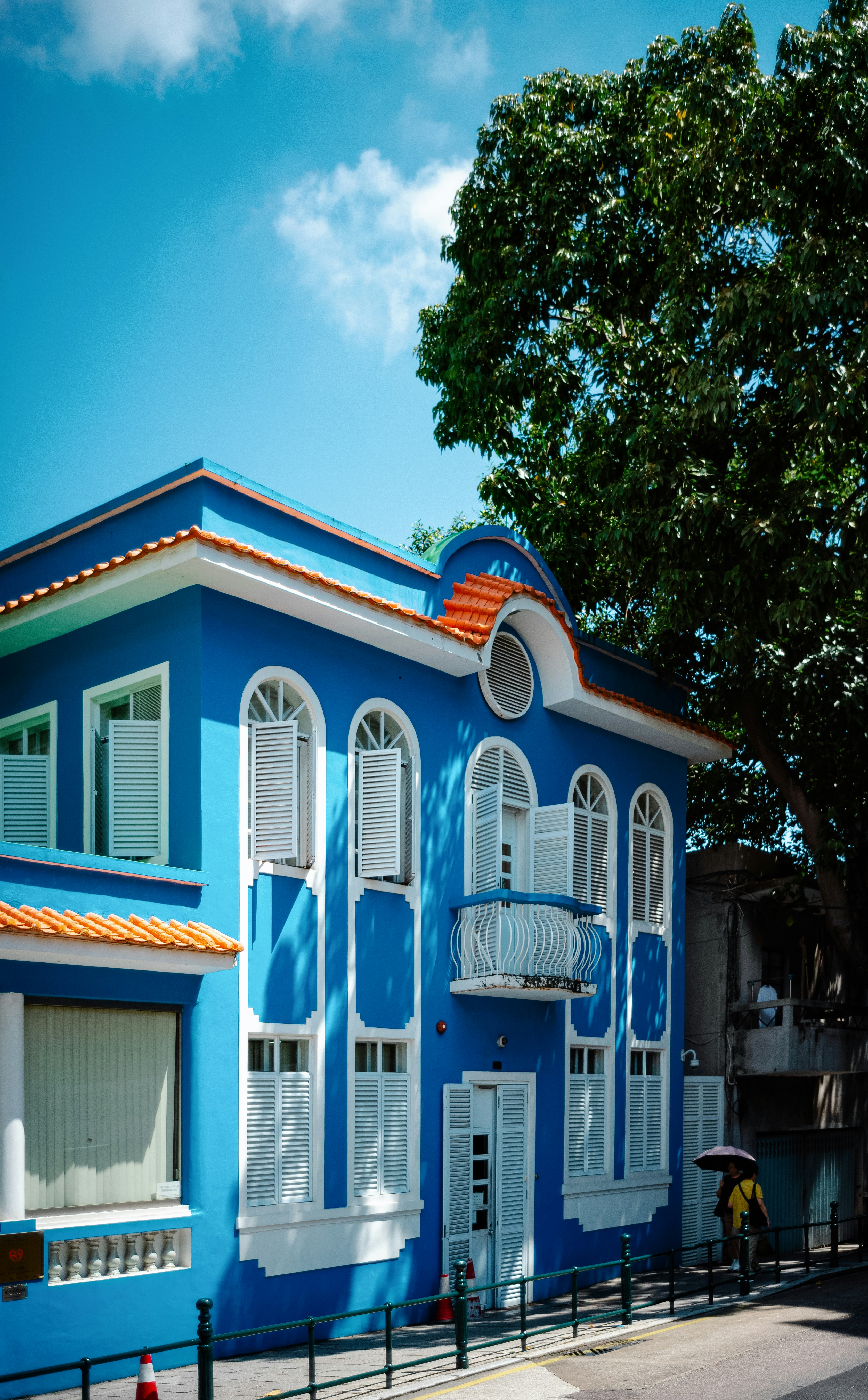 A blue building with white shutters and a balcony photo – Free City ...