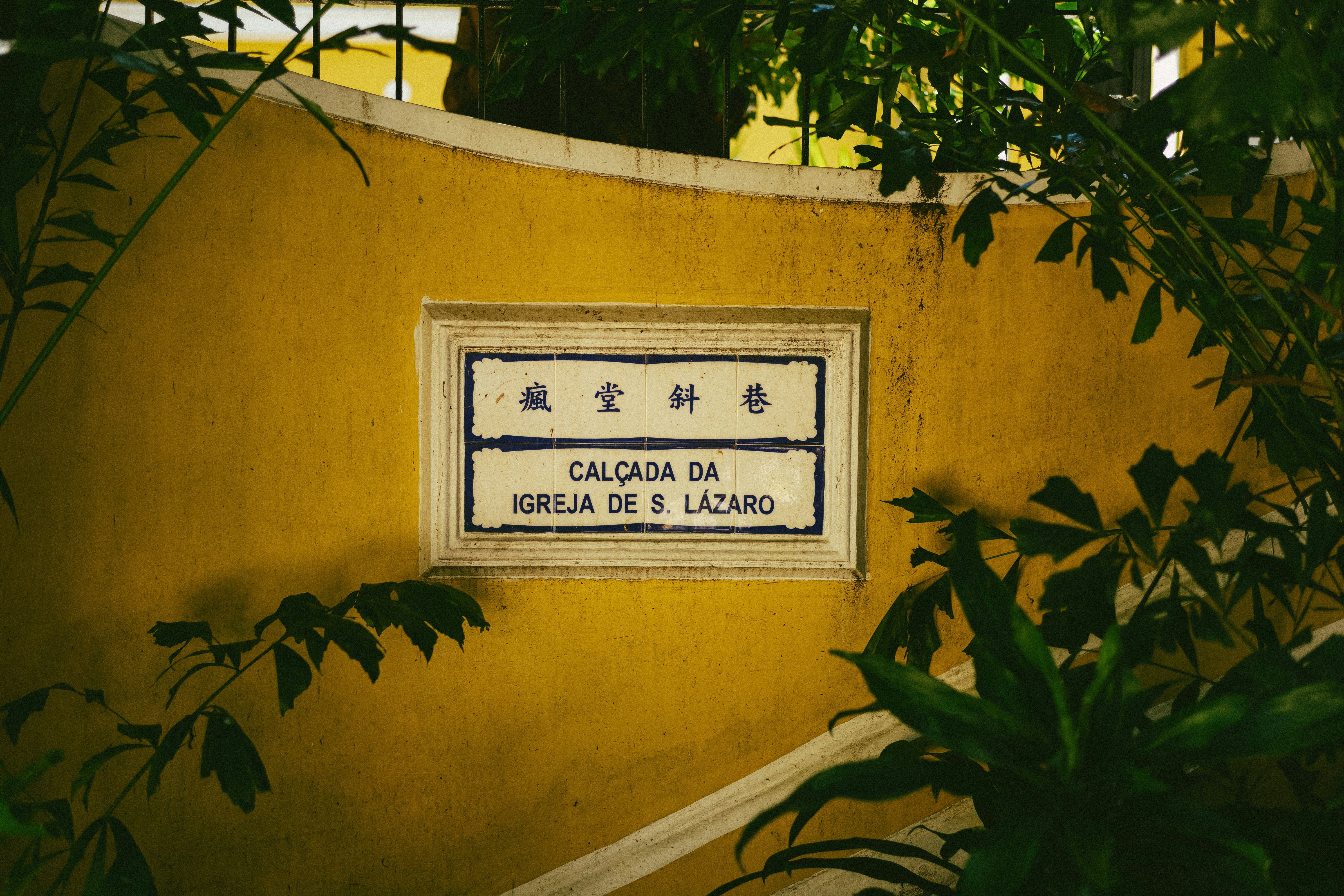 a sign on the side of a yellow wall