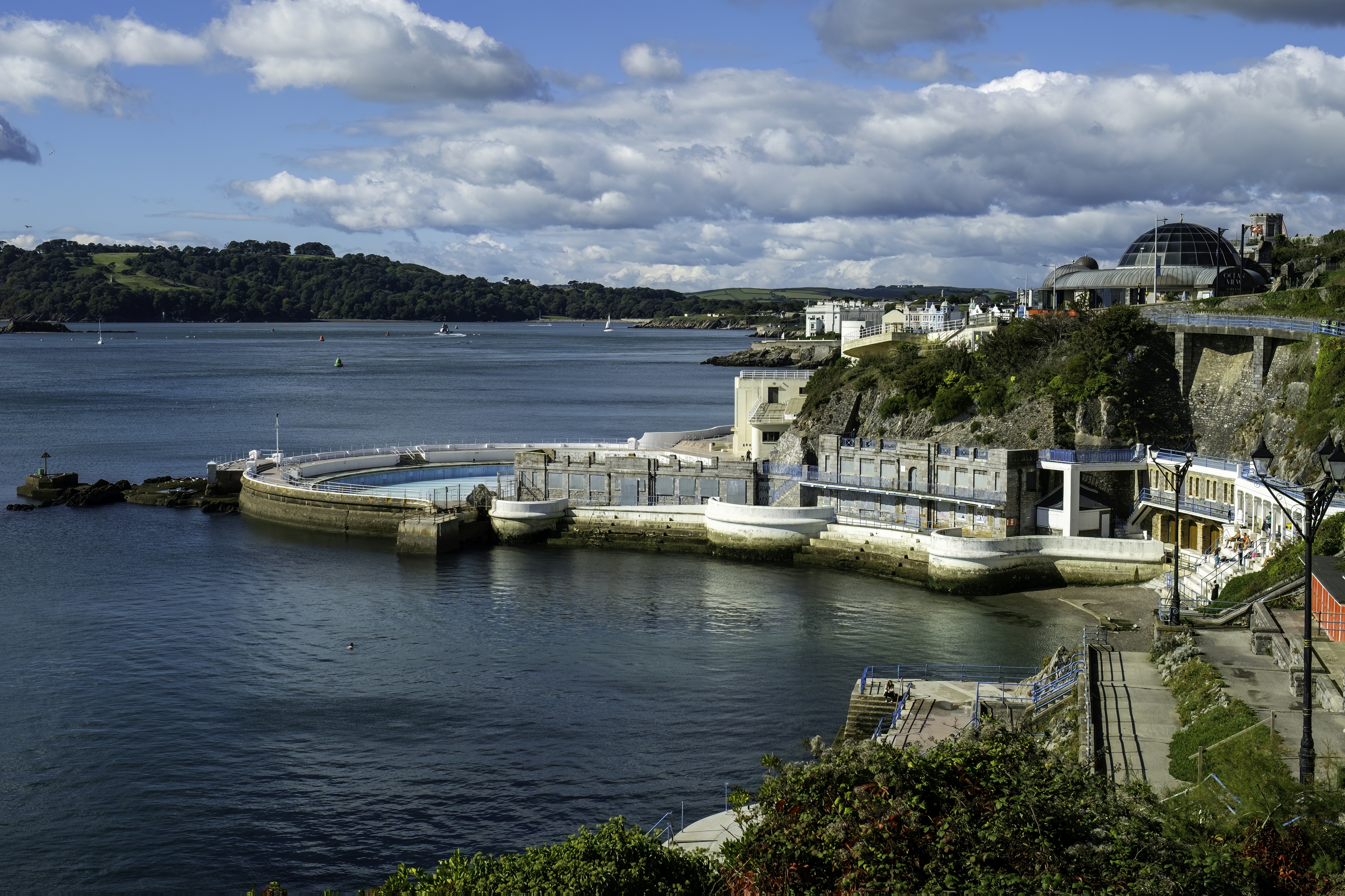 a body of water surrounded by a lush green hillside