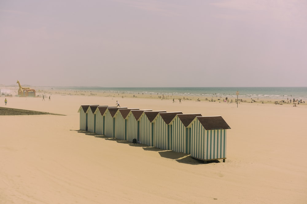 a row of beach huts sitting on top of a sandy beach