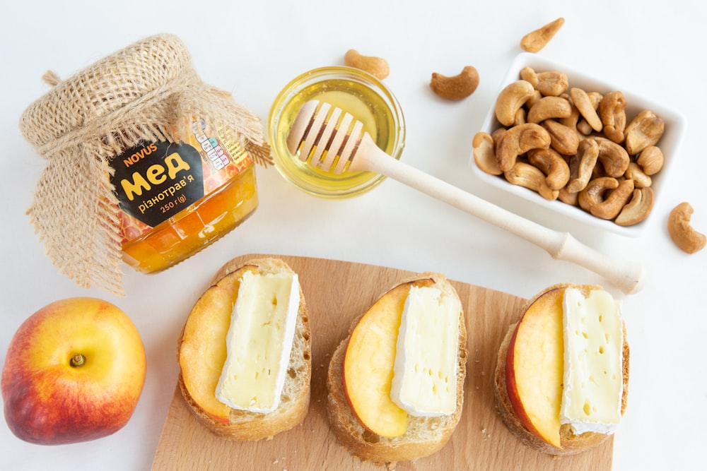 a wooden cutting board topped with three sandwiches