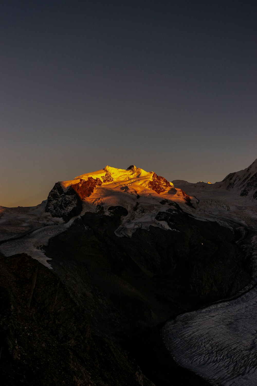 a snow covered mountain with a bright light on top of it