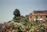 A serene sunrise over a terracotta-roofed villa surrounded by olive trees.