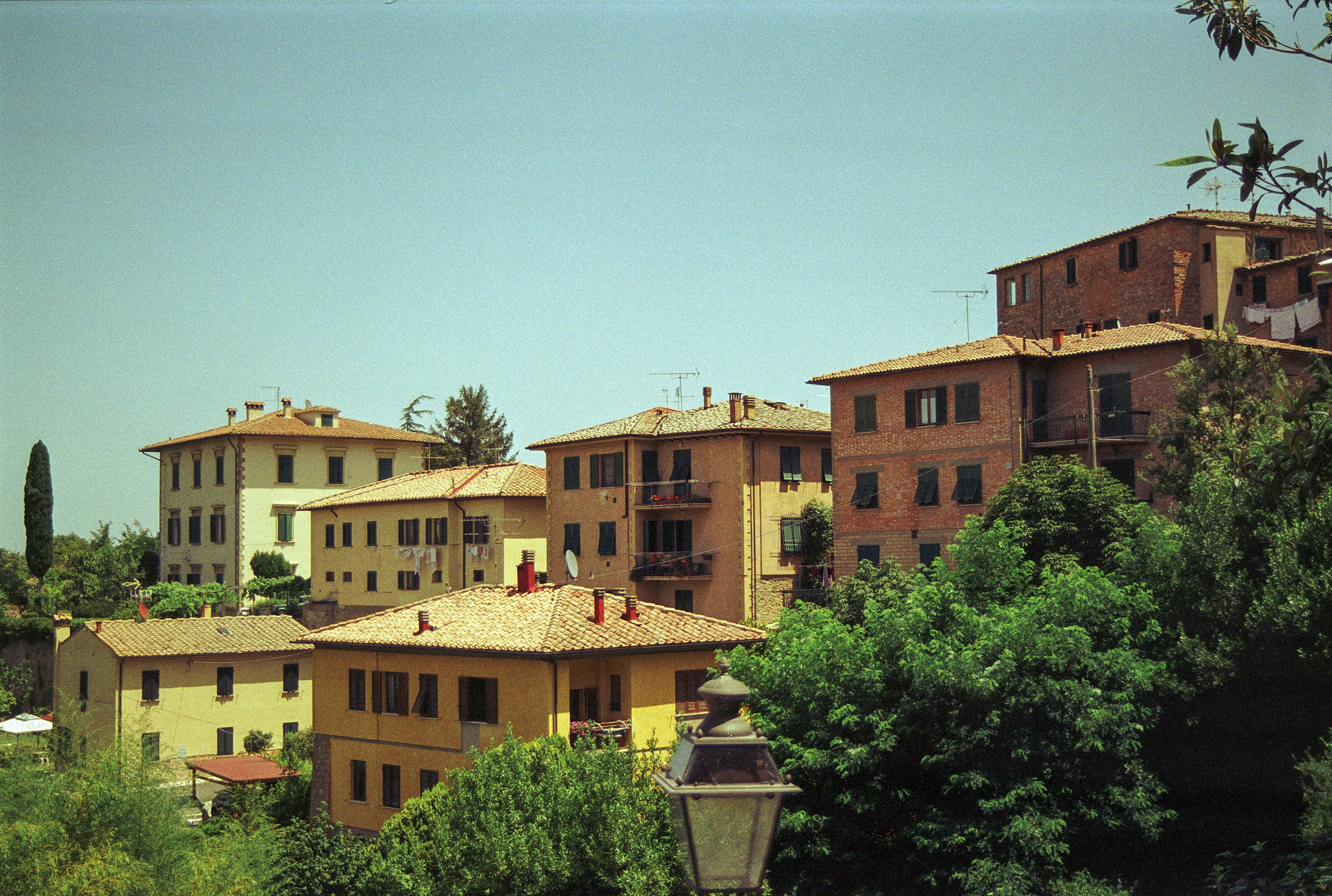 a group of buildings sitting on top of a lush green hillside