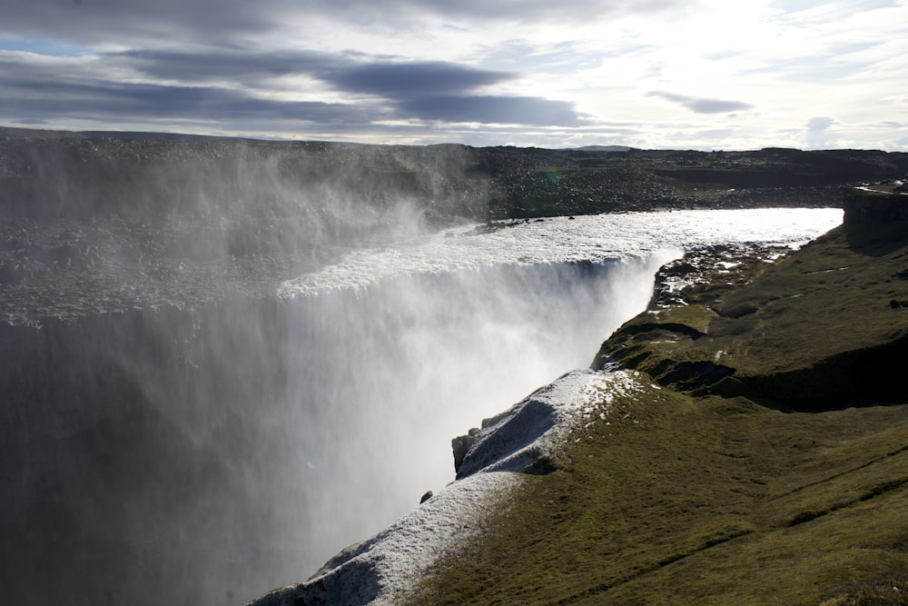 a view of a waterfall from the side of a cliff