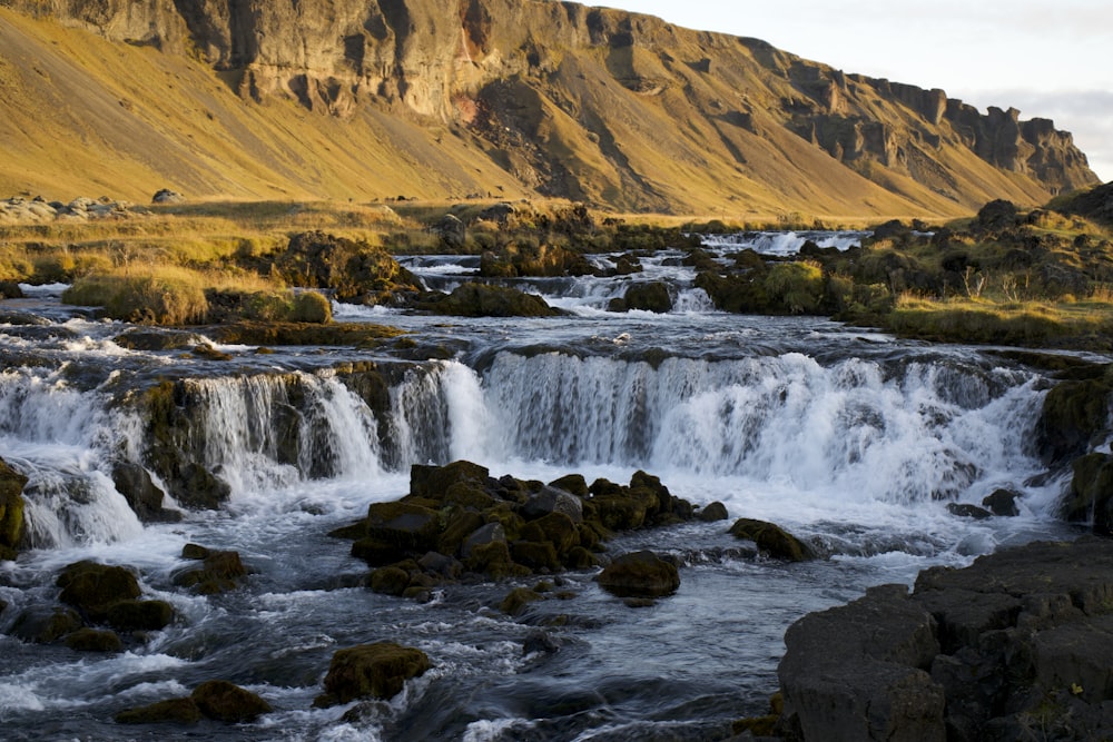 a small waterfall in the middle of a mountain