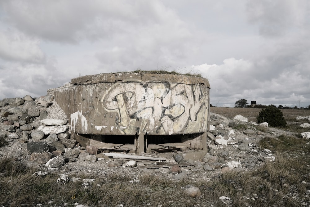 a concrete structure with graffiti on it in a field