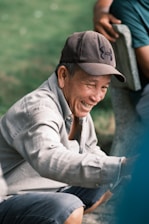 A smiling caregiver chatting warmly with an elderly man on a sunlit porch.