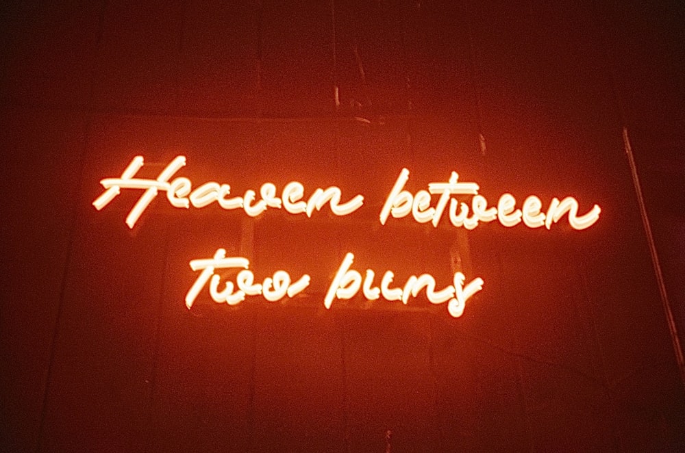 a neon sign that says heaven between two bunnies