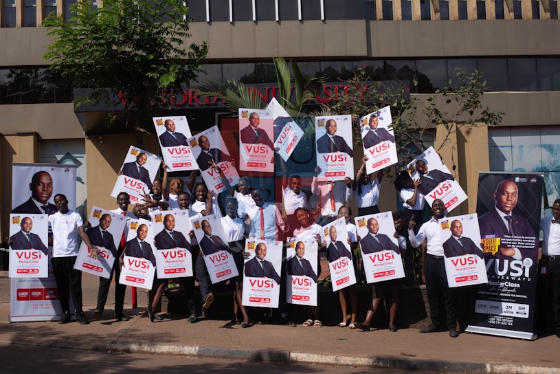A vibrant collage of smiling clients holding up their successful advertising campaign posters.
