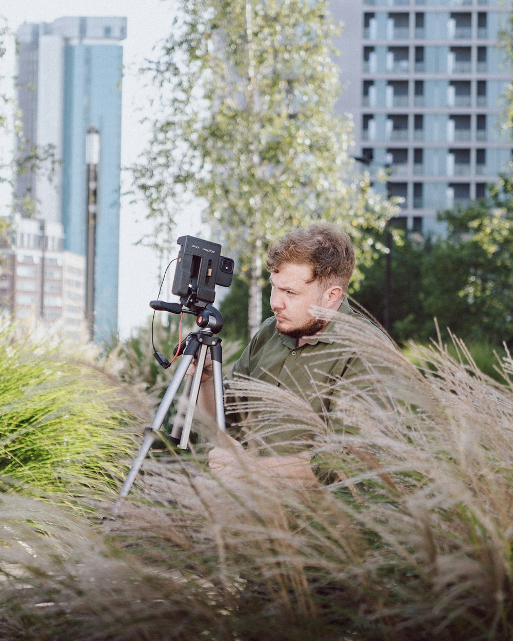 a man sitting in a field with a camera