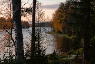A peaceful lakeside scene with reflections of colorful autumn leaves.