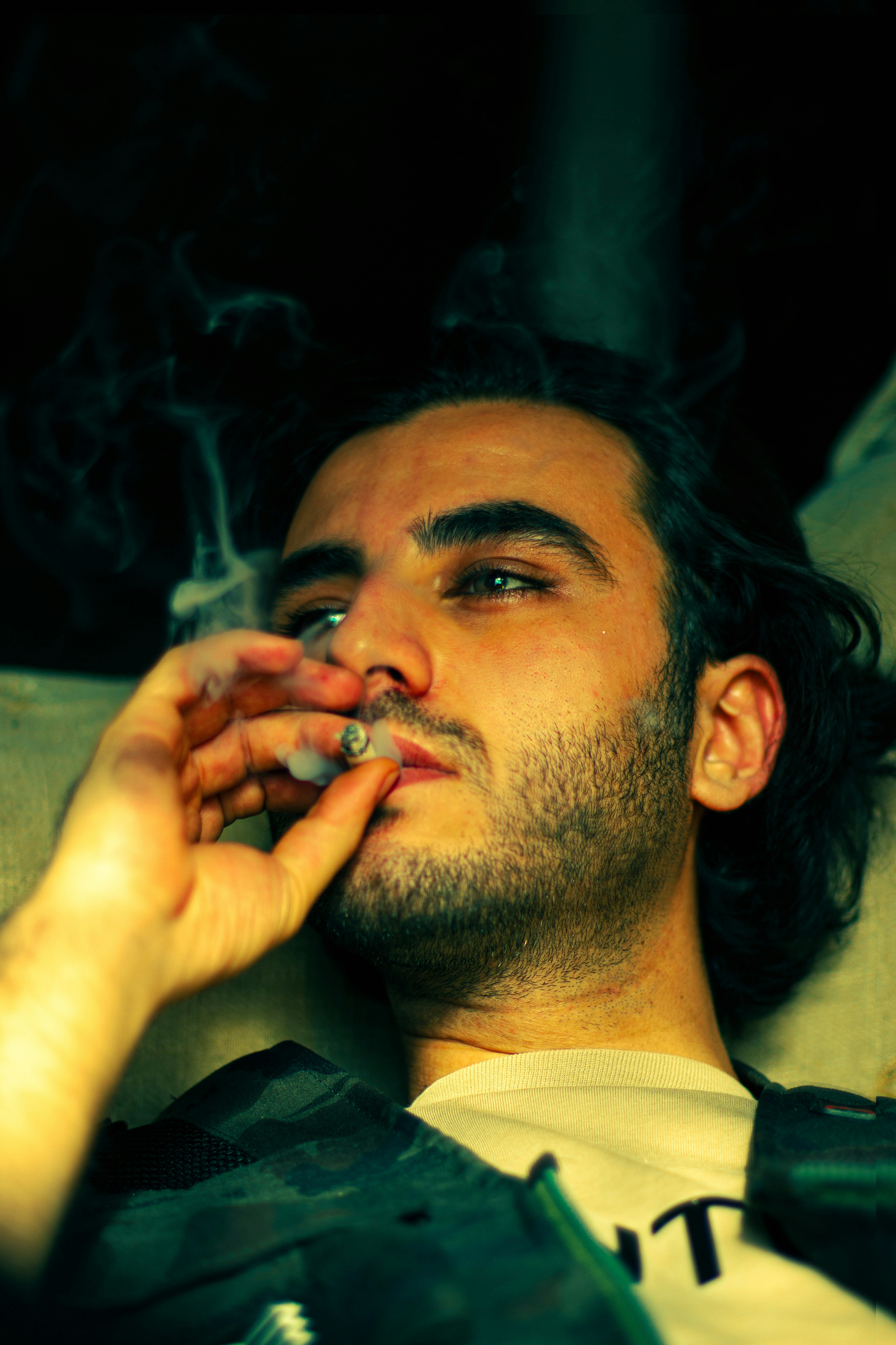 A man laying on a couch smoking a cigarette photo – Free Man Image on  Unsplash