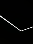 A minimalist design featuring a single white angular line traversing a black background, creating a stark contrast and geometric aesthetic.