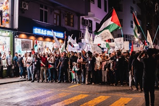 a group of people standing on a street holding flags