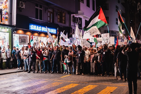 a group of people standing on a street holding flags