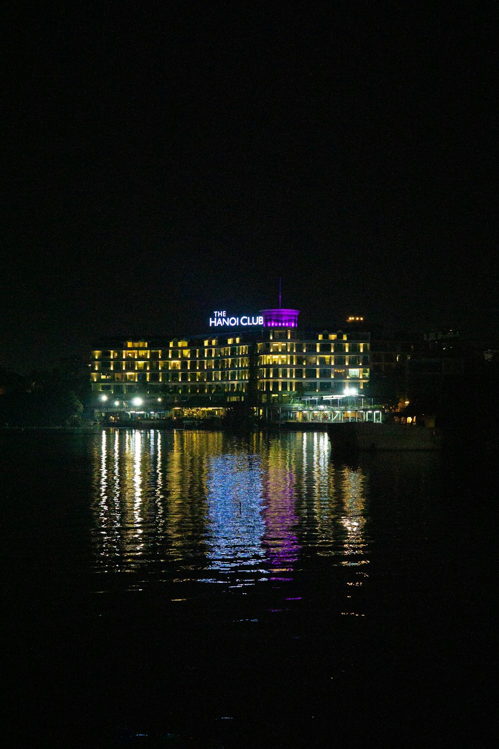 a hotel lit up at night on the water