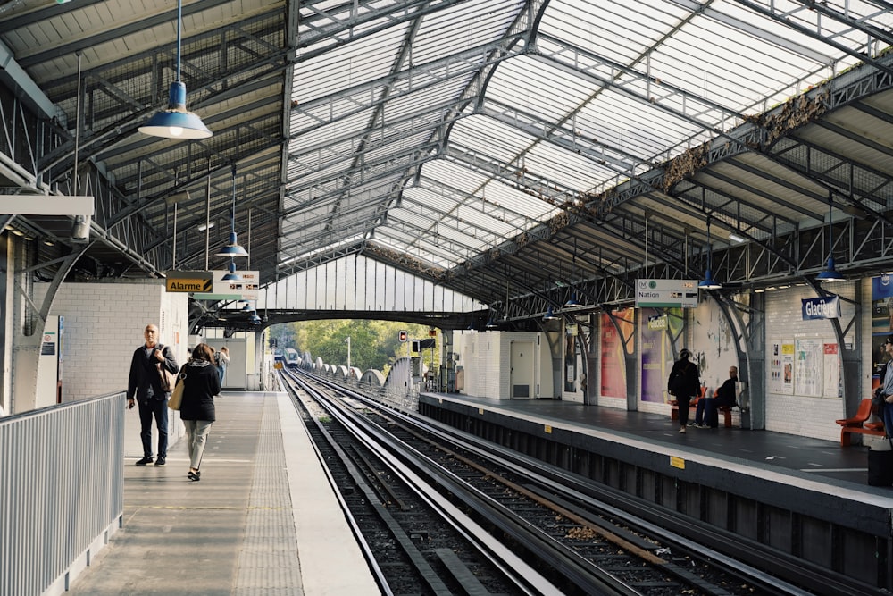 a train station with people walking on the platform