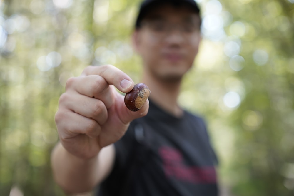 ein Mann, der einen kleinen Gegenstand in der Hand hält