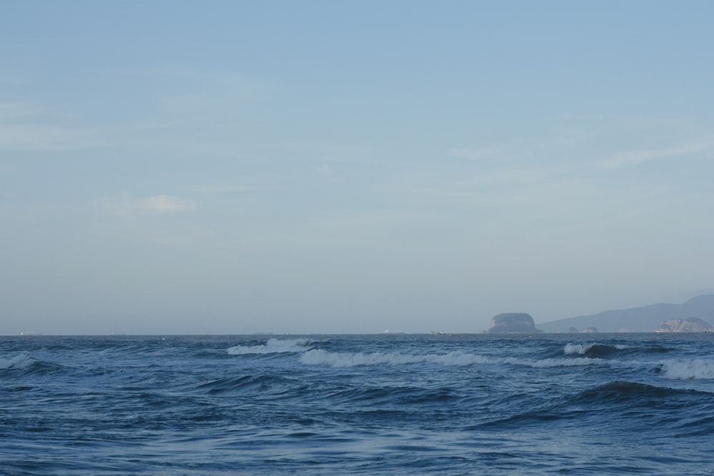 una gran masa de agua con una pequeña isla en la distancia