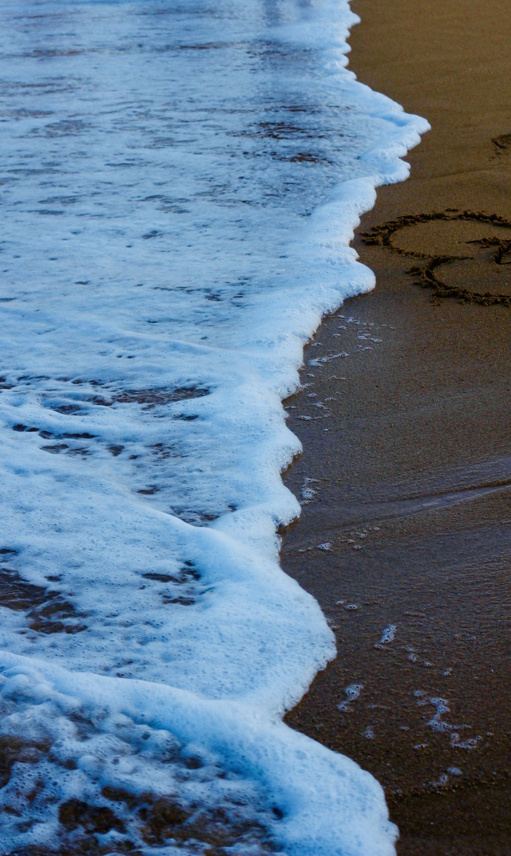 un corazón dibujado en la arena de una playa