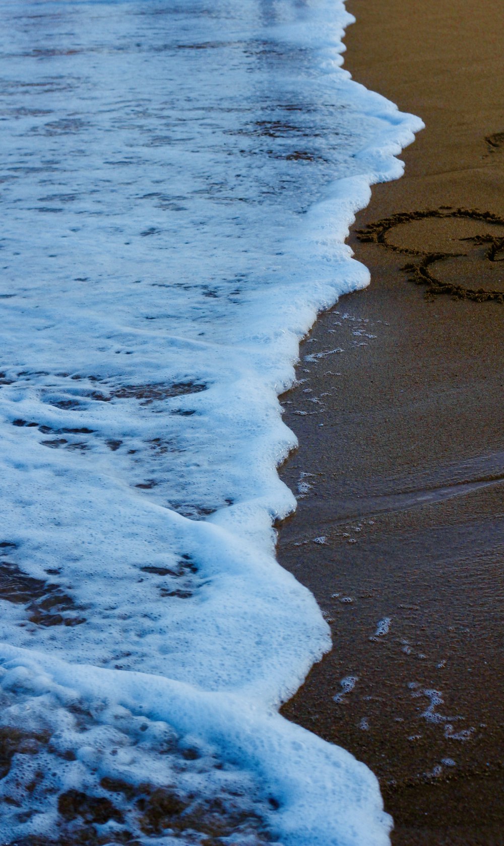 a heart drawn in the sand on a beach